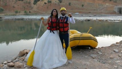 Couple fou fait du rafting avec robe de mariée et marié