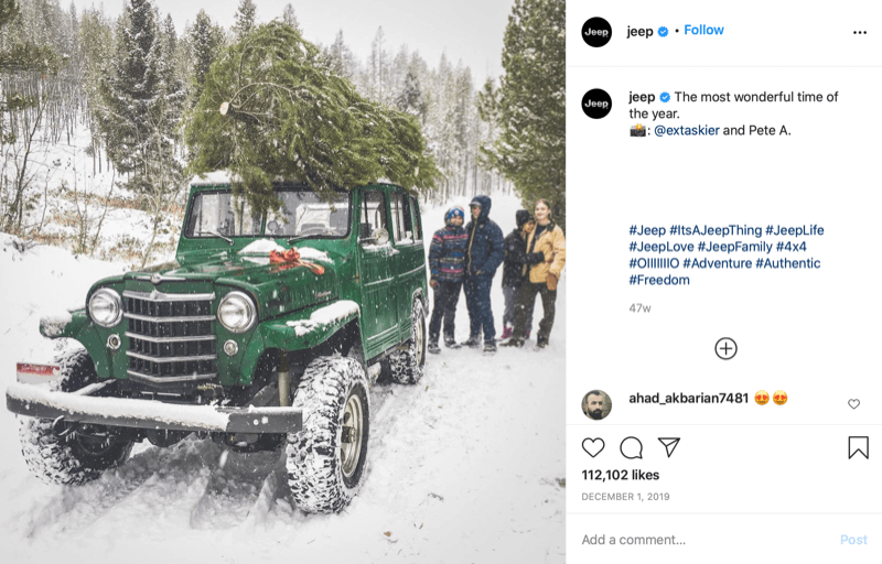 post instagram de @jeep montrant une famille à la fin de la chasse au sapin de Noël avec un arbre au sommet de leur jeep, au fond de la neige et des arbres