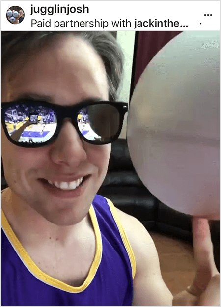 Josh Horton publie une photo pour une campagne avec Jack in the Box et les LA Lakers. Josh porte des lunettes de soleil miroir et un maillot des Lakers et sourit à la caméra tout en faisant tourner une balle.